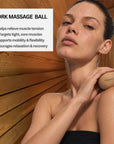 Woman using the Embrace Cork Massage Ball on her shoulder in a sauna to help relieve muscle tension, support mobility, and encourage relaxation.
