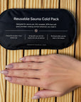 Embrace reusable sauna cold pack shown next to a hand for size comparison on a wooden sauna bench.