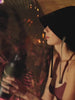 Woman drinking from a stainless steel water bottle with a heat-safe wrap in the sauna. 