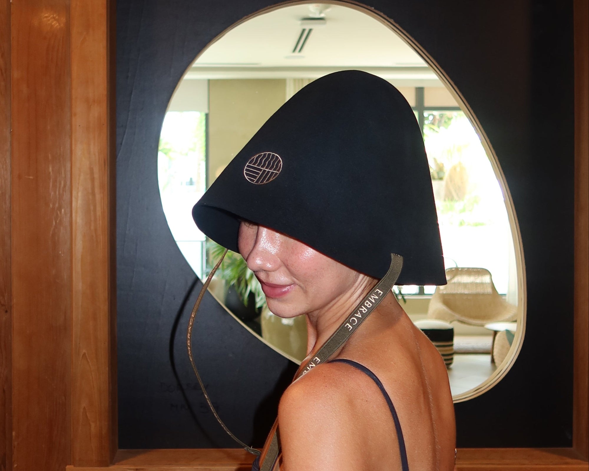 Woman wearing an oversized black 100% Australian merino wool sauna hat in a traditional sauna